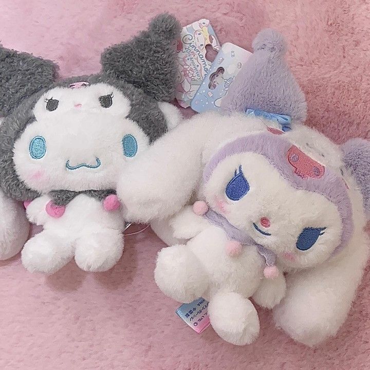 three stuffed animals laying on top of a pink blanket