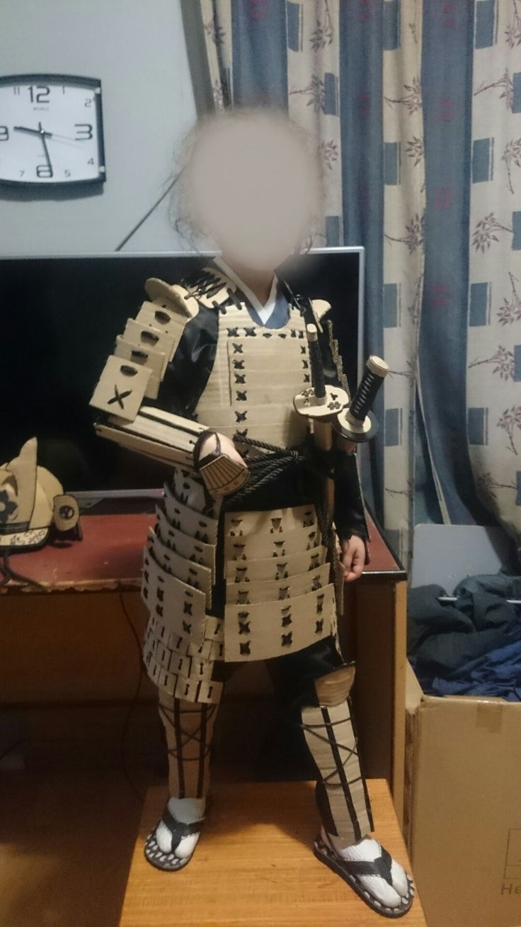 a cardboard cut out of a man in armor standing next to a desk with a clock on it