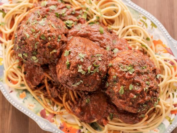 spaghetti and meatballs on a plate with parsley