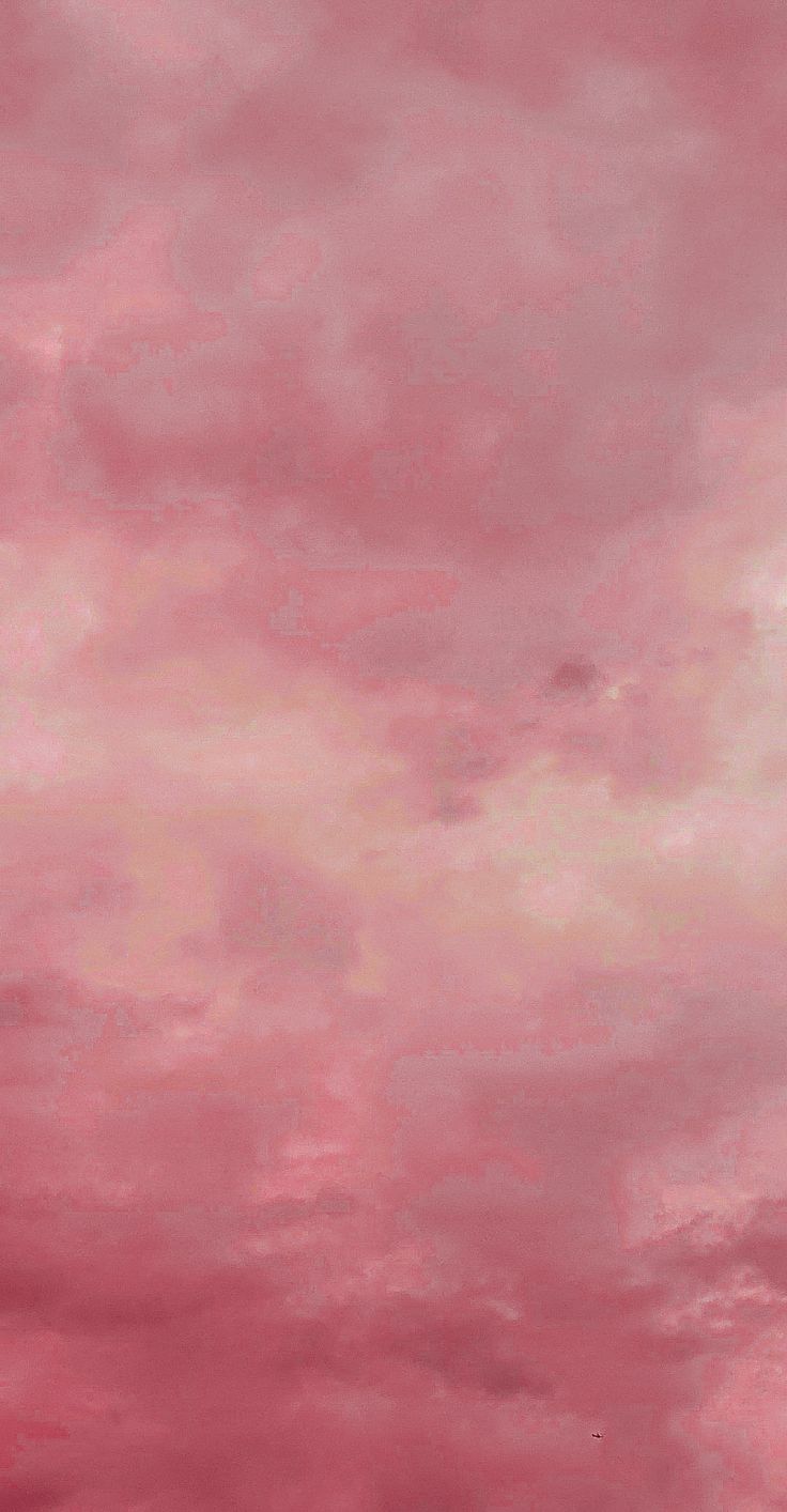 an airplane flying in the sky with pink clouds