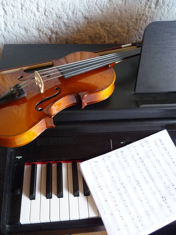 a violin sitting on top of a piano