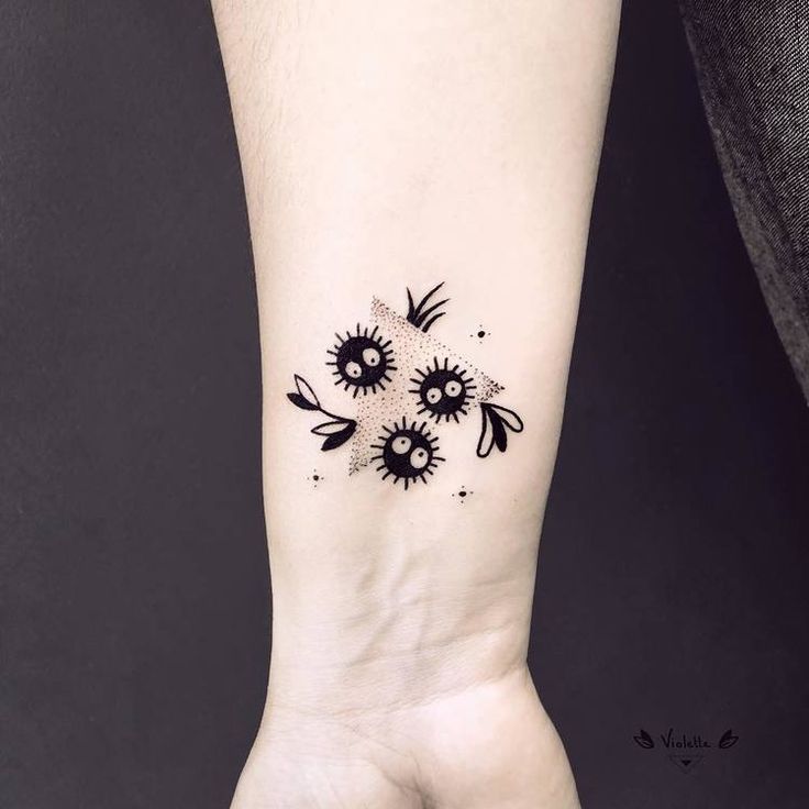 a black and white flower tattoo on the left inner arm, with an arrow in the middle