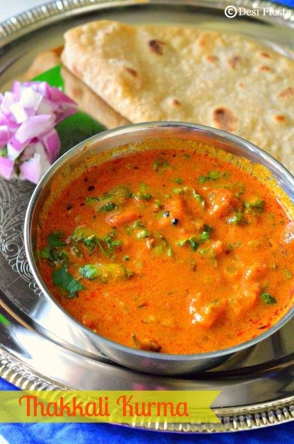 a silver plate topped with a bowl of soup and pita bread