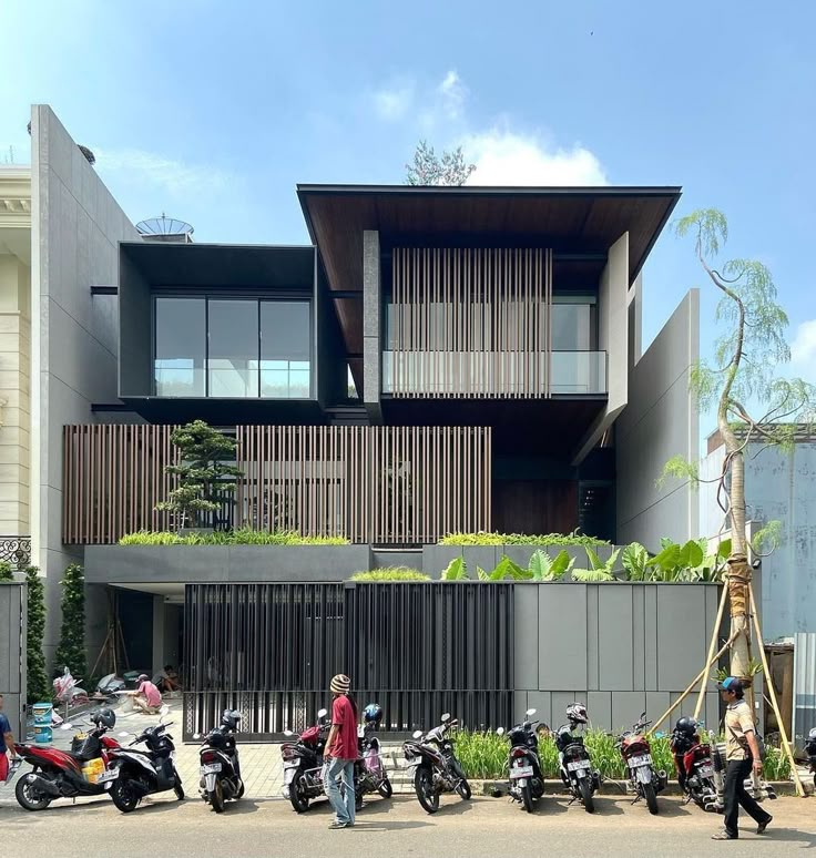 several motorcycles are parked in front of a building with balconies on the roof