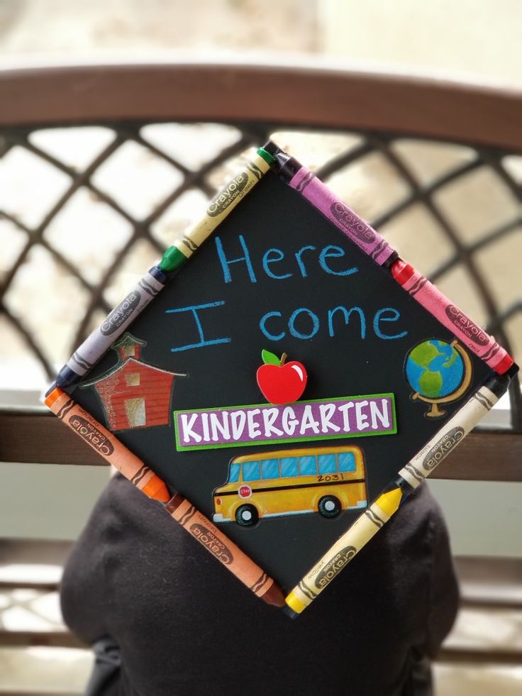 there is a black graduation cap with crayons on it that says here i come