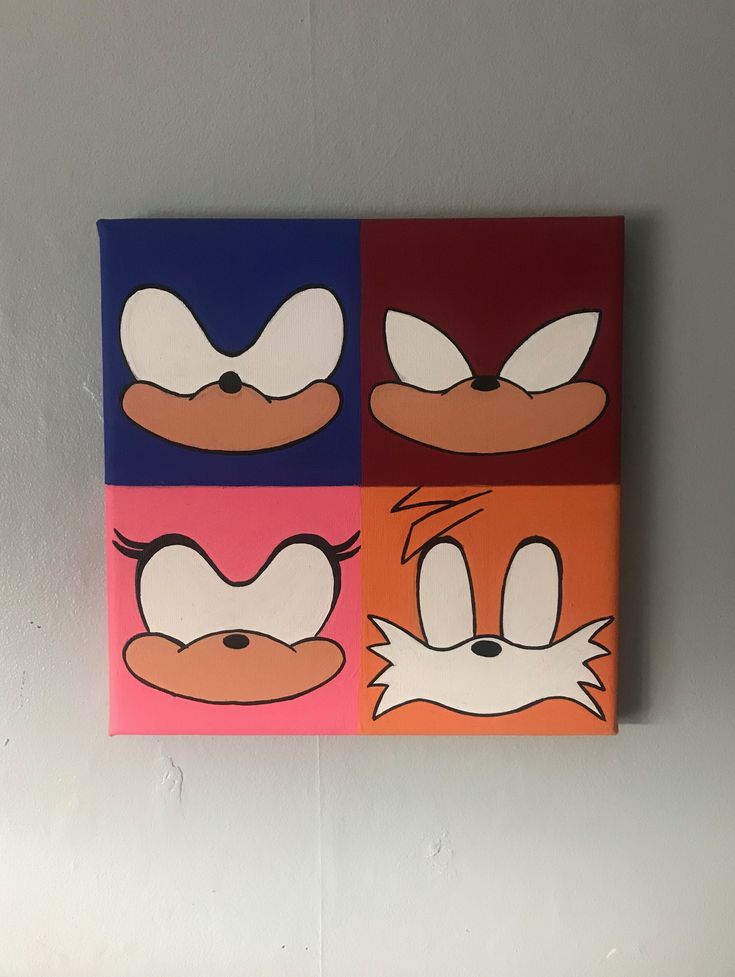 three cartoon faces are painted on canvases in different colors and sizes, one is red, the other is blue