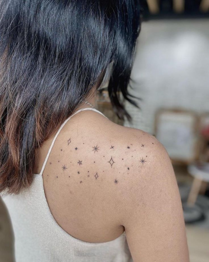 the back of a woman's shoulder with small stars on her left arm and chest