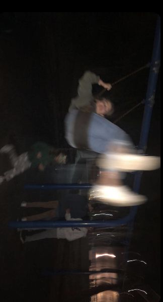 a man riding a skateboard down the side of a metal hand rail at night