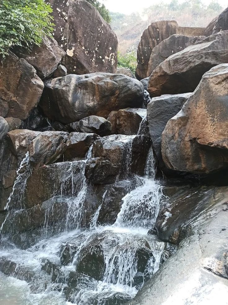 there is a small waterfall in the middle of some rocks