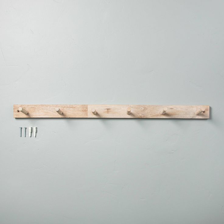 three wooden pegs are hanging on the wall