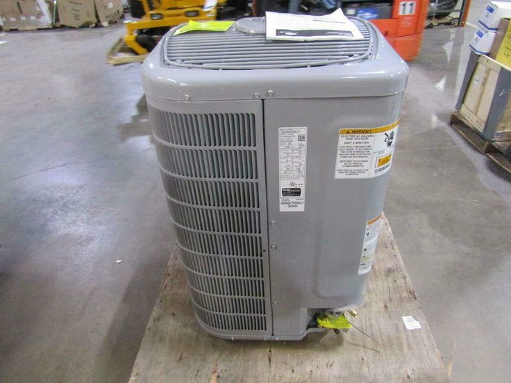 an air conditioner sitting on top of a wooden pallet in a room filled with boxes