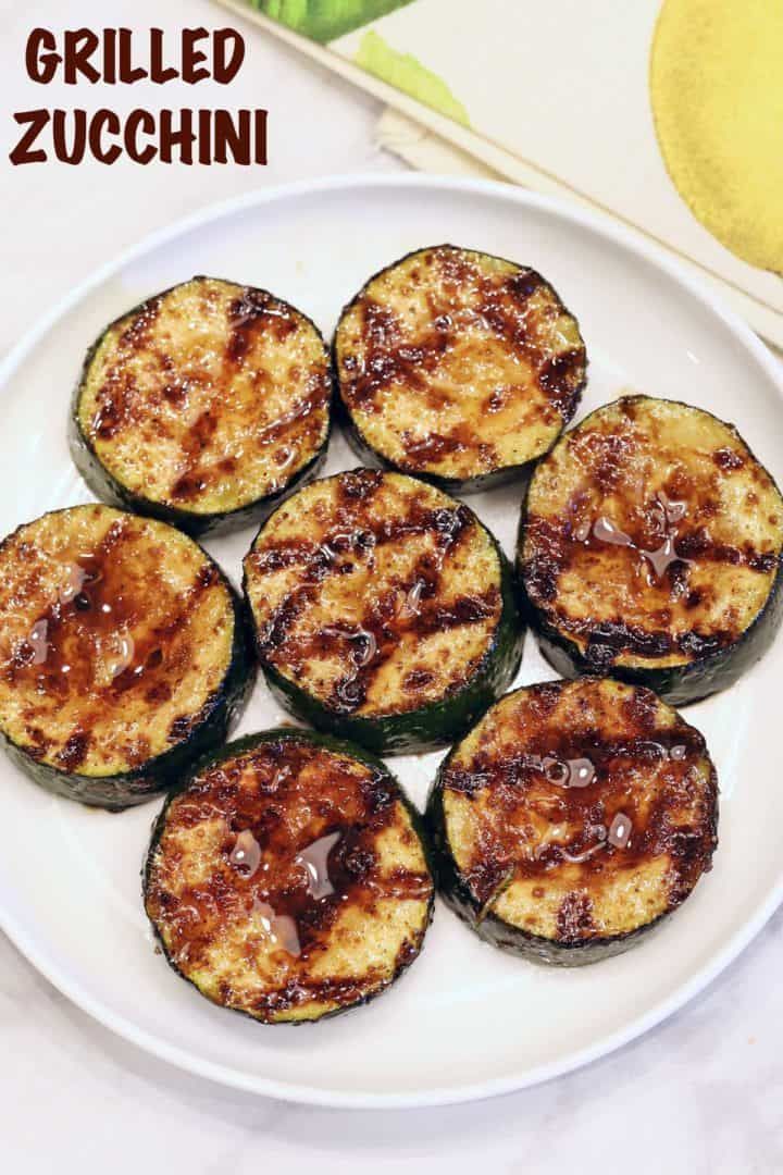 an image of grilled zucchini on a plate with text overlay that reads perfectly grilled zucchini