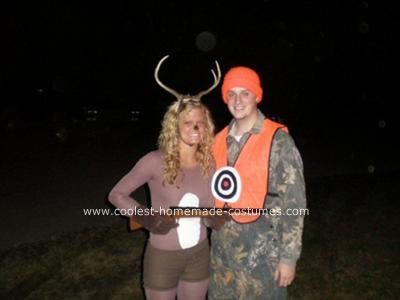 two people dressed up as deer and antlers at night time, posing for the camera