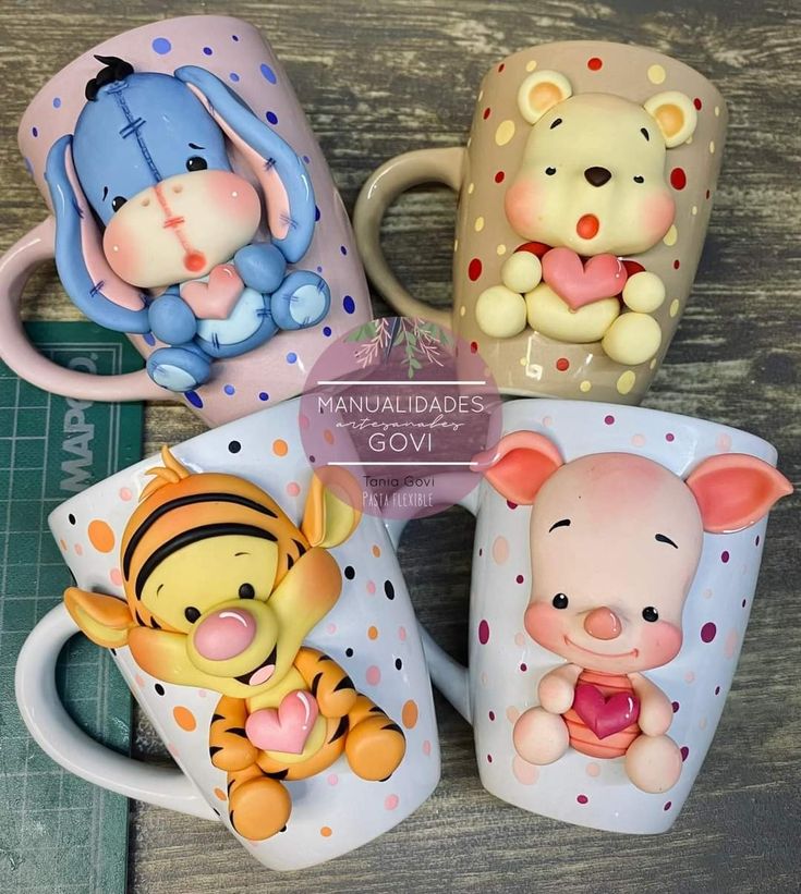 four winnie the pooh mugs sitting on top of a table