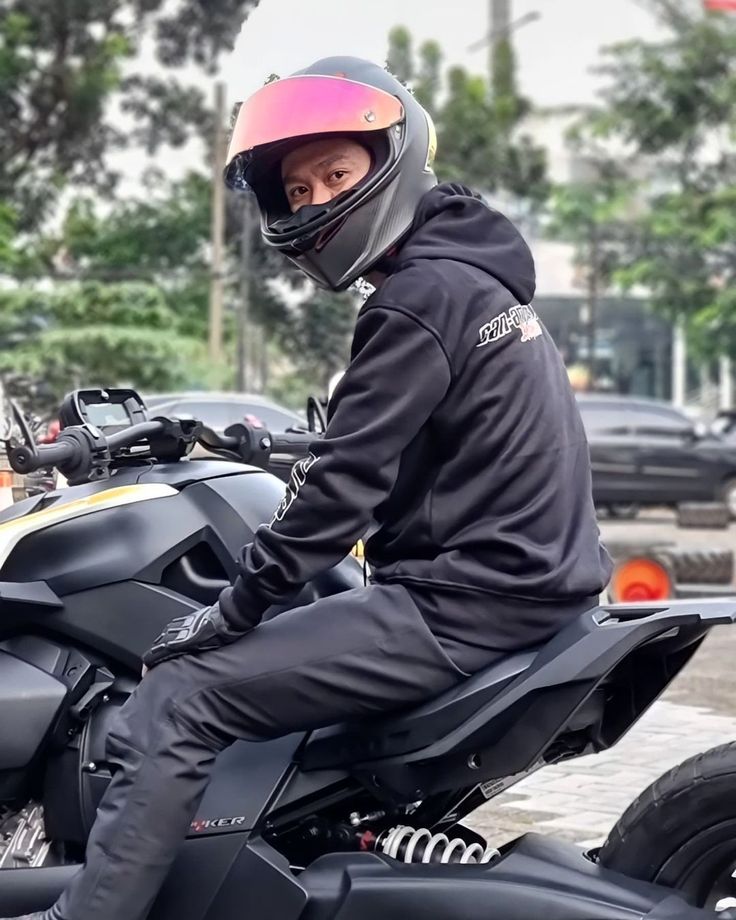 a man wearing a helmet sitting on a motorcycle