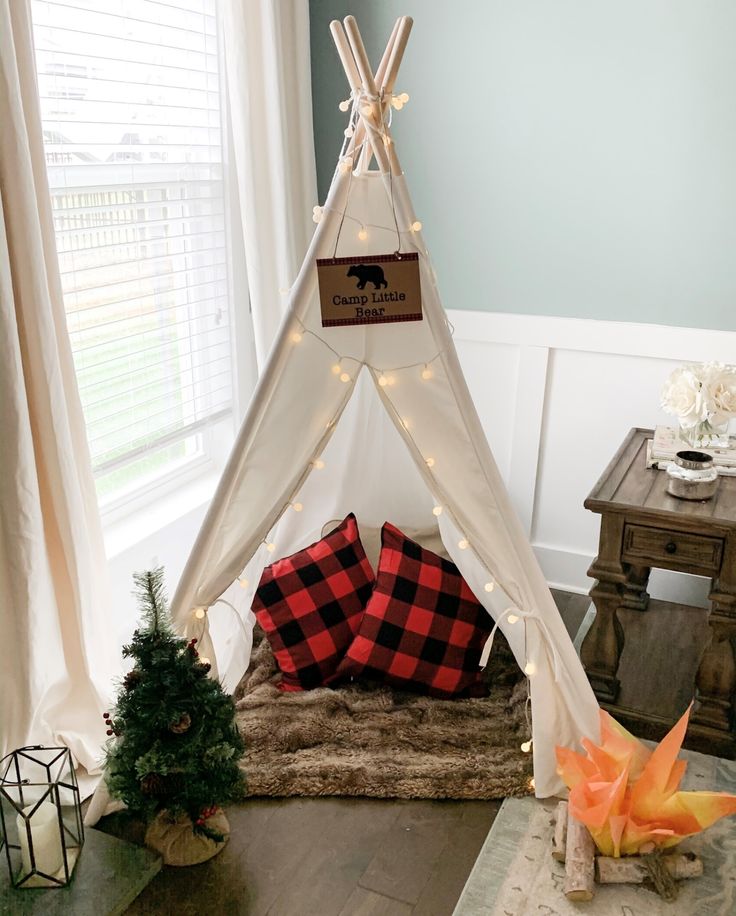 a teepee with lights and pillows on the floor