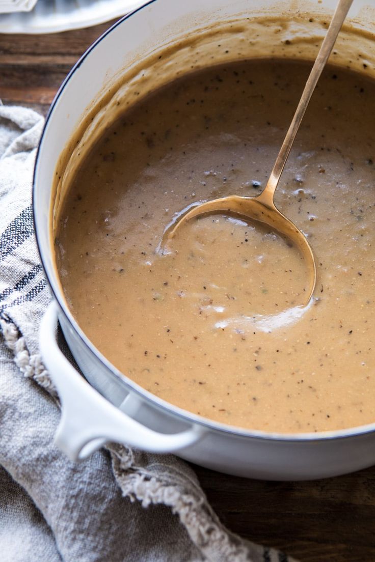 a wooden spoon in a pot filled with soup