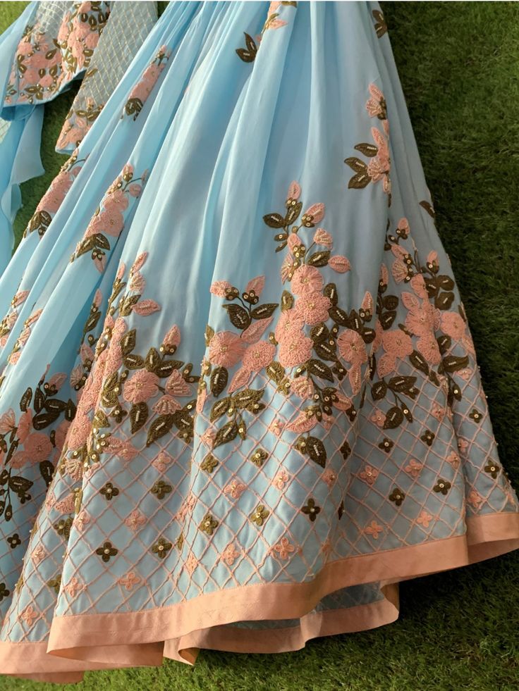 This traditional ensemble is detailed with thread work and a glance of light gold work on the lehenga and blouse. This outfit is completed with a contemporary look of a ruffle dupatta. Traditional Sets With Floral Embroidery For Reception, Floor-length Embroidered Art Silk Sets, Floor-length Embroidered Sets For Reception, Floor-length Embroidered Georgette Sets, Elegant Lehenga With Floral Embroidery In Traditional Drape, Elegant Unstitched Lehenga With Floral Embroidery, Elegant Lehenga With Floral Embroidery, Designer Chanderi Choli With Intricate Embroidery, Elegant Raw Silk Lehenga With Floral Embroidery