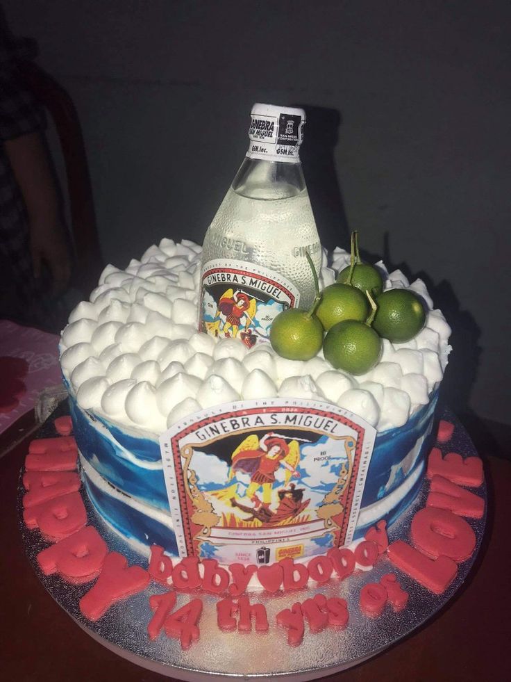 a birthday cake with a bottle and two limes on top