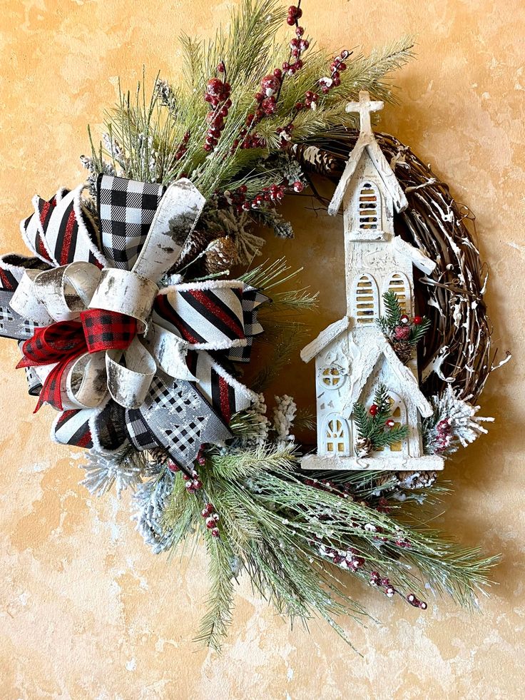 a wreath with a church and christmas decorations