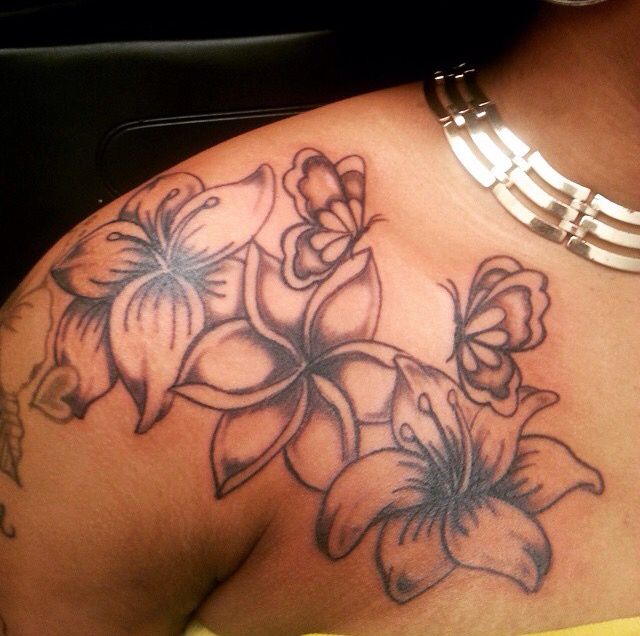 a close up of a woman's shoulder with flowers on the chest and arm