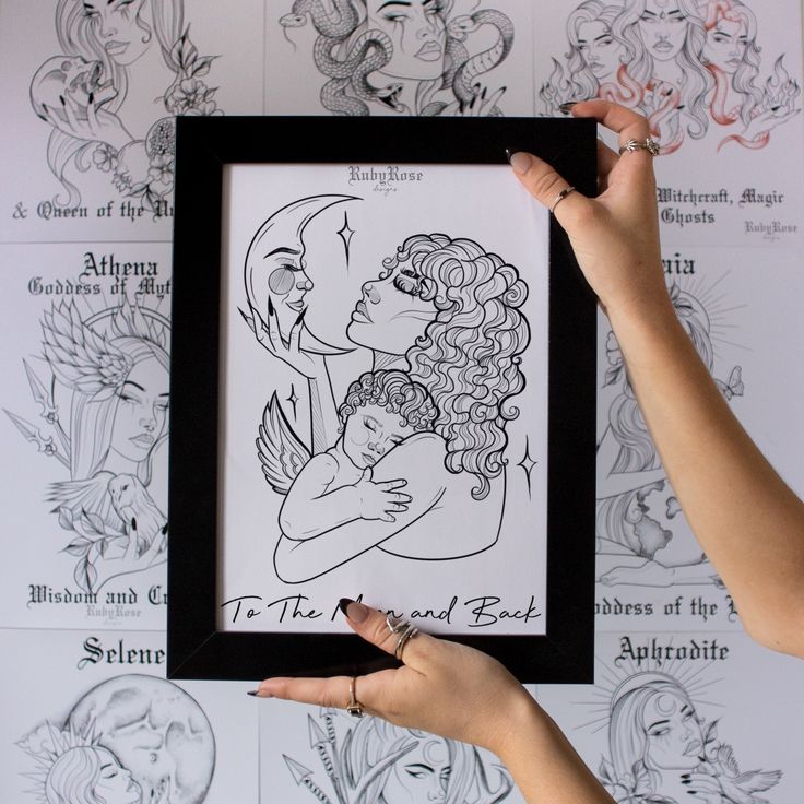 a woman is holding up a framed drawing