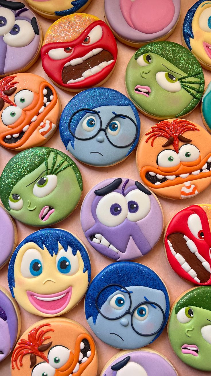 there are many decorated cookies with different faces on them, including one that looks like the characters from inside out