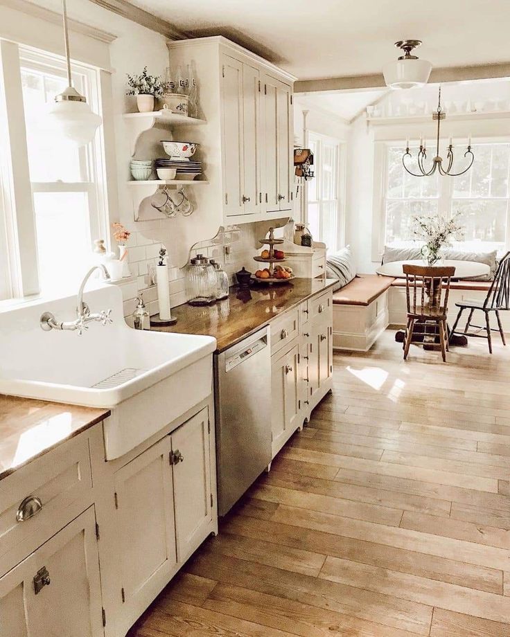 a kitchen with white cabinets and wooden floors