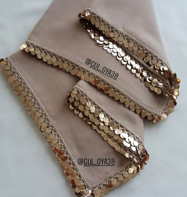 three pieces of cloth with gold sequins on them sitting next to each other