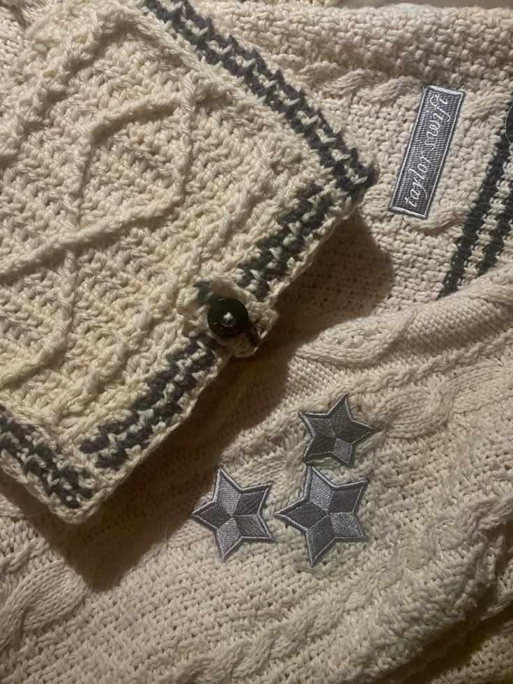 a white sweater with stars on it is laying on the floor next to an object