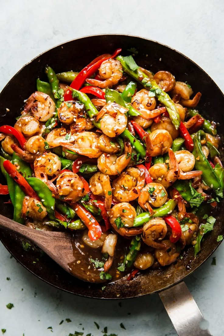 a skillet filled with shrimp and vegetables