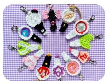 there are many crocheted keychains arranged in a circle on a purple and white checkered tablecloth