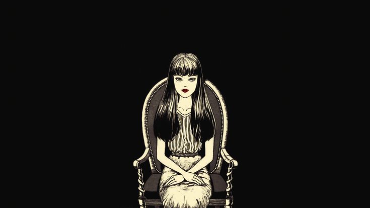 a woman sitting on top of a chair in the dark