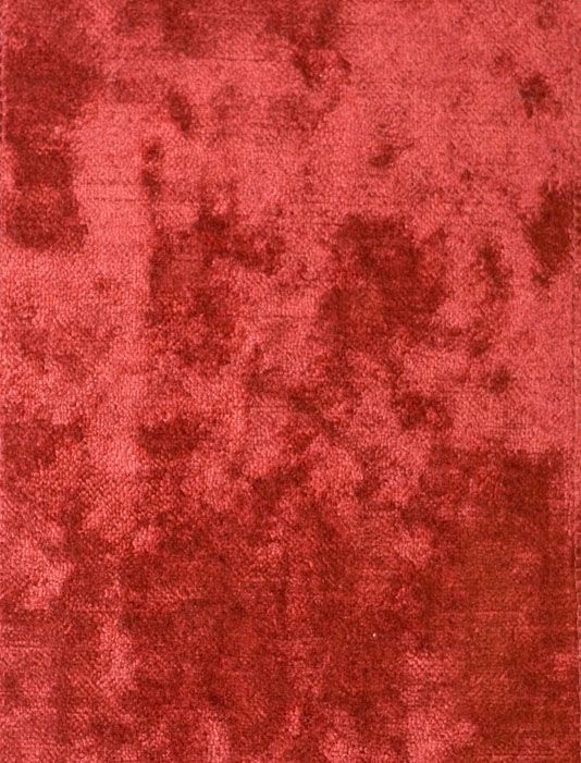 a red area rug that has been cleaned and is very worn out with some stains on it