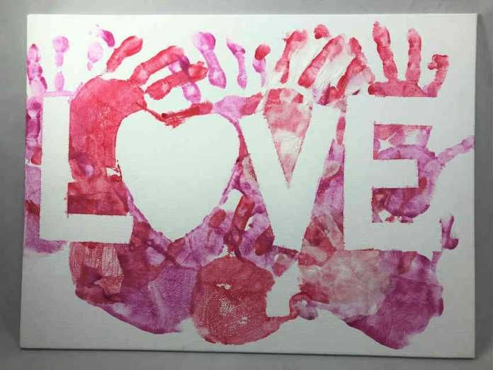 a piece of paper with the word love painted on it in red and pink colors