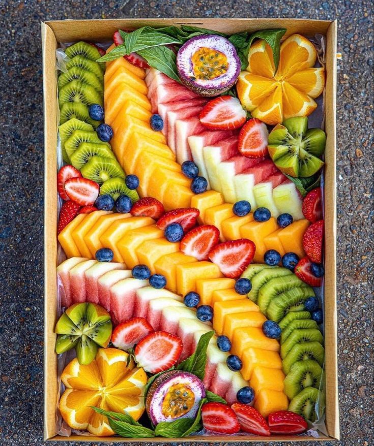 a box filled with cut up fruit on top of a floor next to a wall