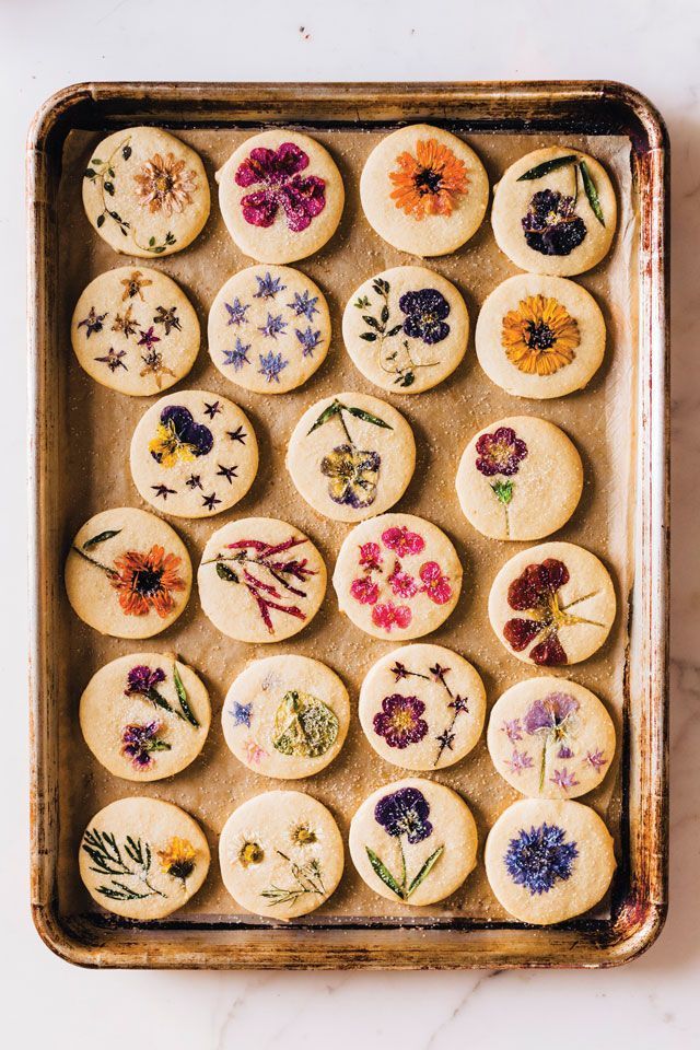 a baking pan filled with cookies covered in edible flowers