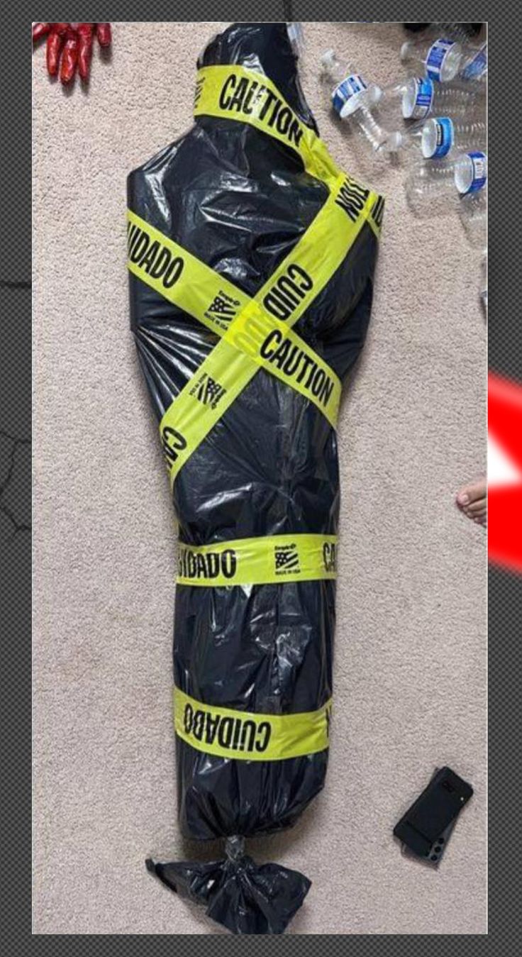 a bag that is wrapped in plastic and taped to the ground with caution tape on it