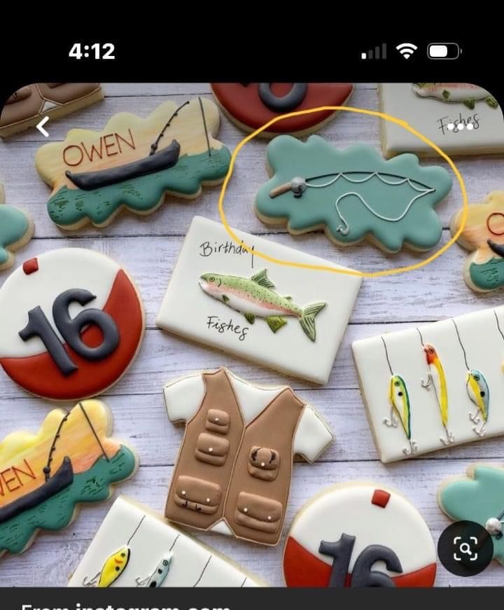 decorated cookies with fishing related items displayed on wooden table top, including one for the number sixteen