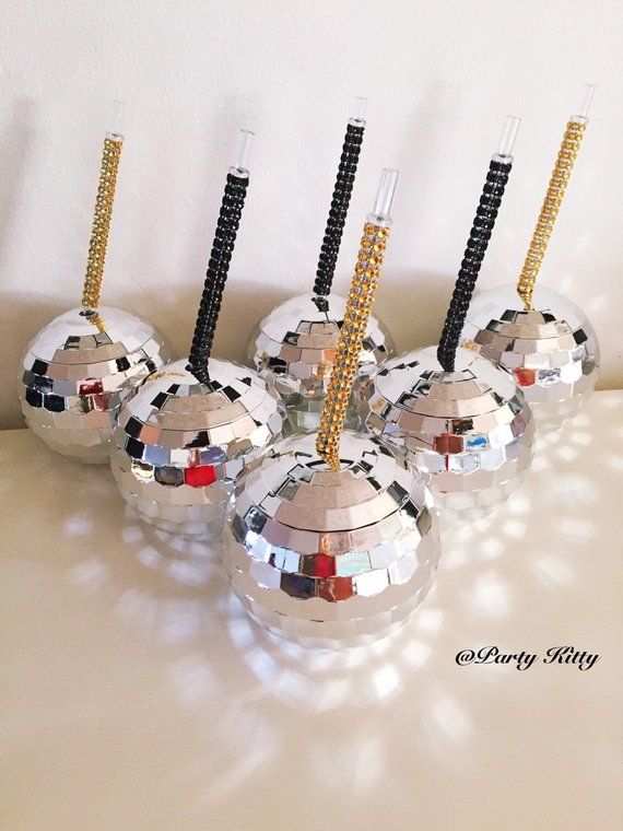 six disco ball candles are lined up on a table with one candle in the middle