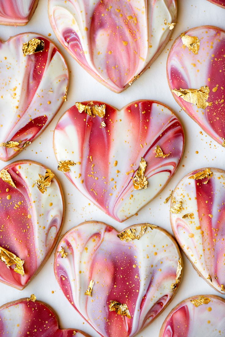 pink and white heart shaped cookies with gold flecks on them, arranged in the shape of hearts