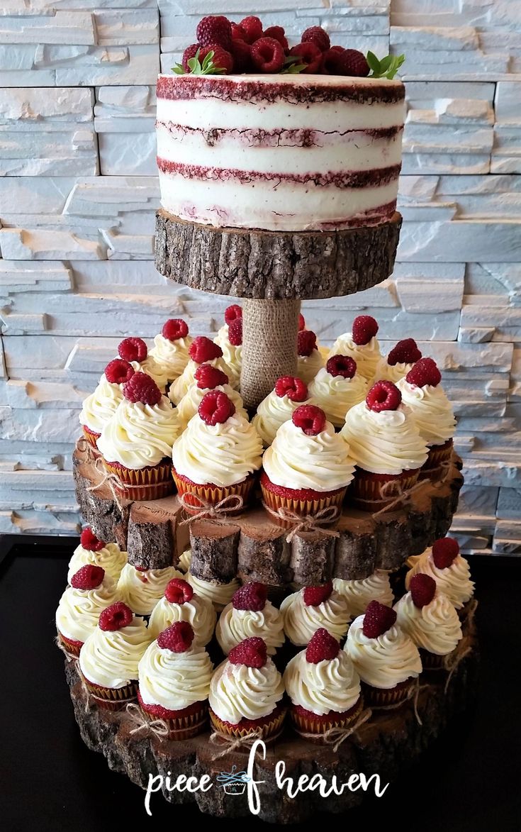 a three tiered cake with white frosting and raspberries on top is displayed