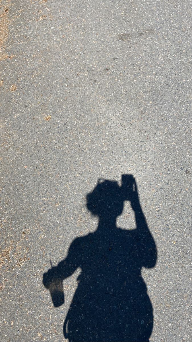 a shadow of a person holding a baseball glove