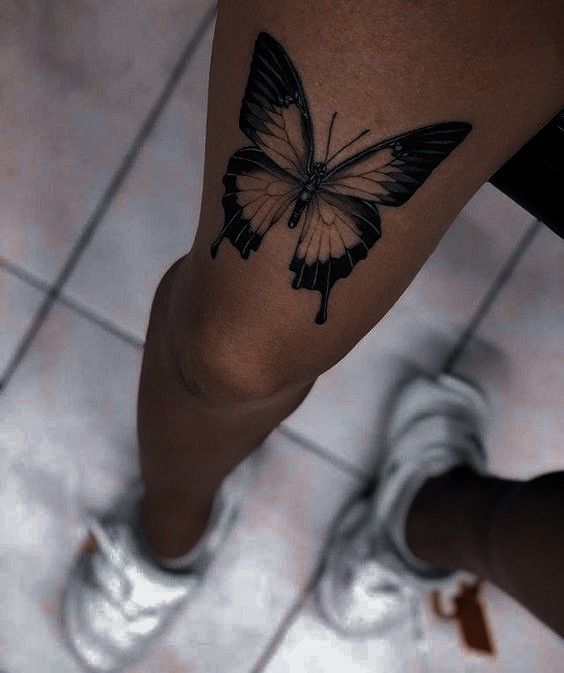 a woman's leg with a butterfly tattoo on it