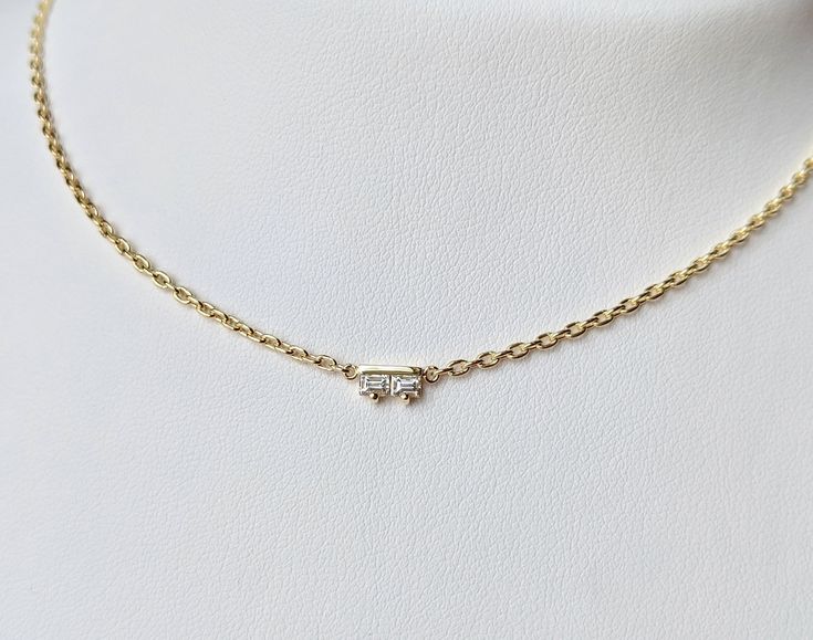 Two stunning baguette diamonds set aside a gold bar make up your new go-to necklace. 18K yellow gold cable chain with lobster clasp Total carat weight: .17 Recycled 18K yellow gold Measurements: 6.5mm/.26in tall, 3.8mm/.15in wide, 2mm/.08in deep This is a GIFT THAT GIVES BACK! Click here to see how. In stock and ready to ship! Baguette Necklace, Trending Necklaces, Baguette Diamonds, 18k Gold Jewelry, Ethical Jewelry, Jewelry For Her, Gold Bar, Baguette Diamond, Cable Chain