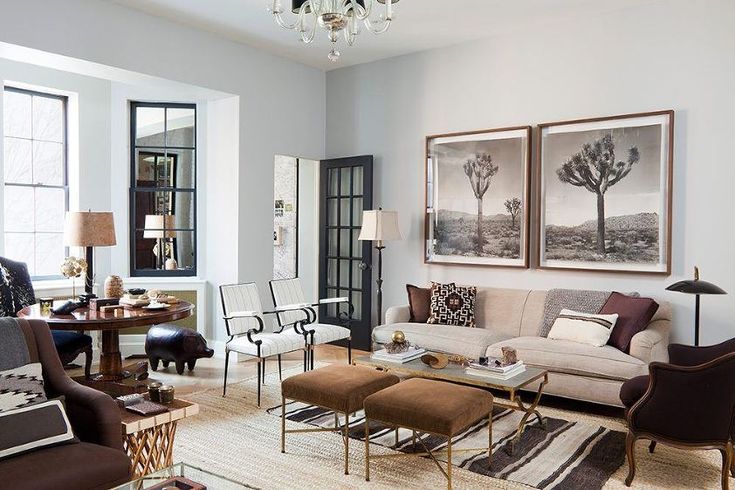 a living room filled with lots of furniture and paintings on the wall above it's windows