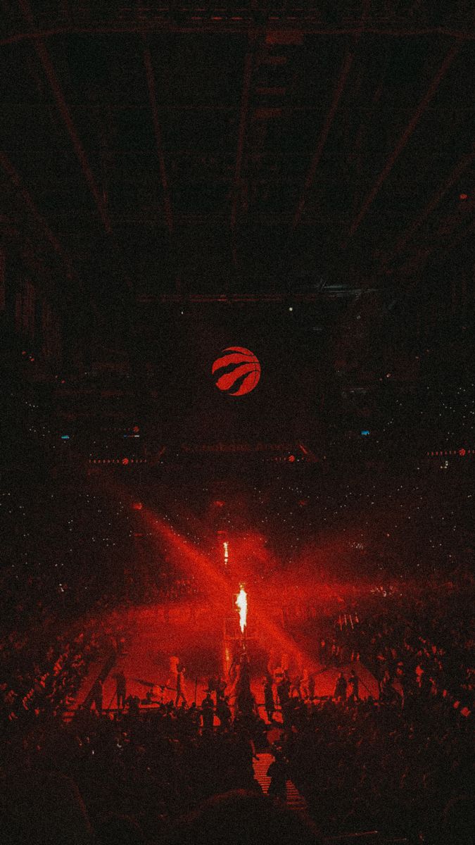 the audience at a concert is lit up with bright red lights and fans are seated in the bleachers