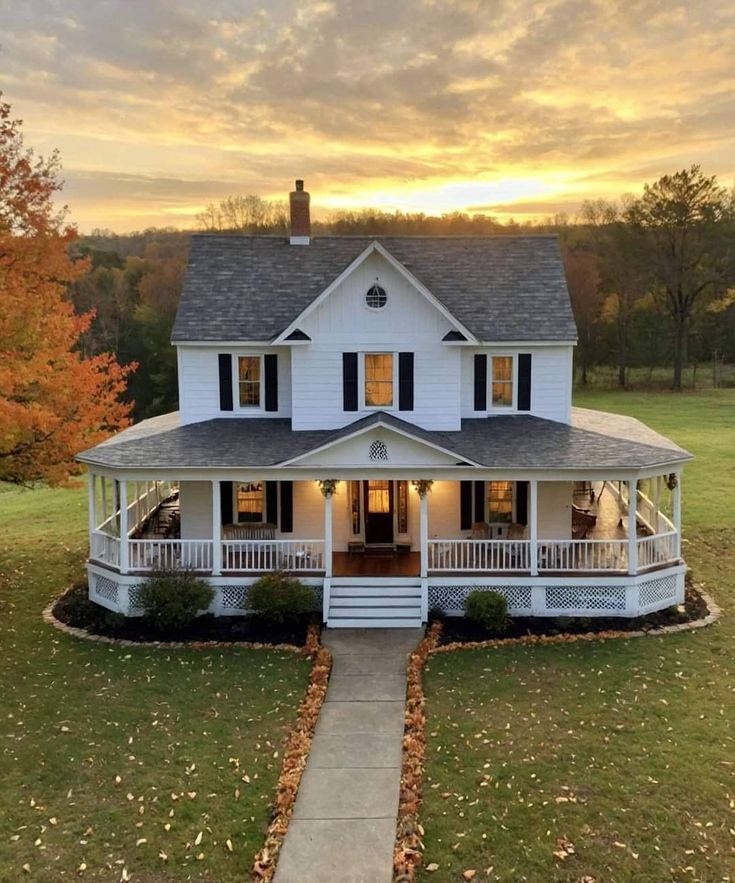 a large white house sitting on top of a lush green field