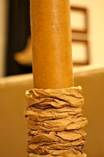 a close up of a brown paper wrapped around a wooden pole in a living room