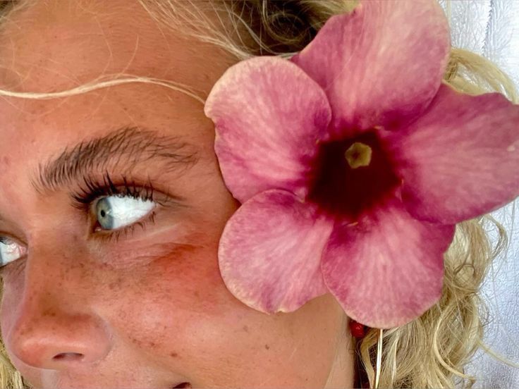 a close up of a woman with a flower in her hair